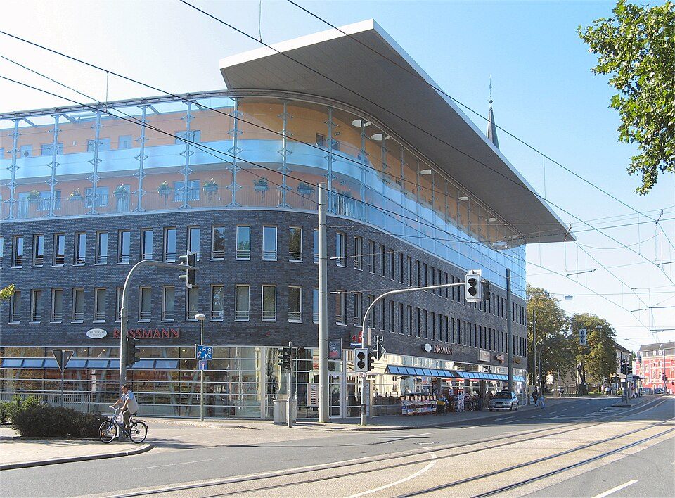 Straßenkreuzung mit Straßenbahngleisen, Ampeln und einem modernen Geschäftshaus in Bochum-Altenbochum