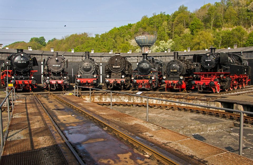 Dampflokomotiven vor dem Ringlokschuppen an der Drehscheibe des Eisenbahnmuseums in Bochum-Dahlhausen, dahinter bewaldete Hänge