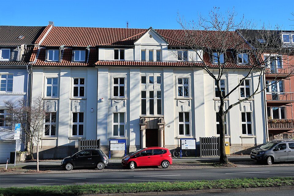 Weiß verputztes Bürgerhaus mit Zwerchgiebel und Sprossenfenstern an der Königsallee im Bochumer Ehrenfeld