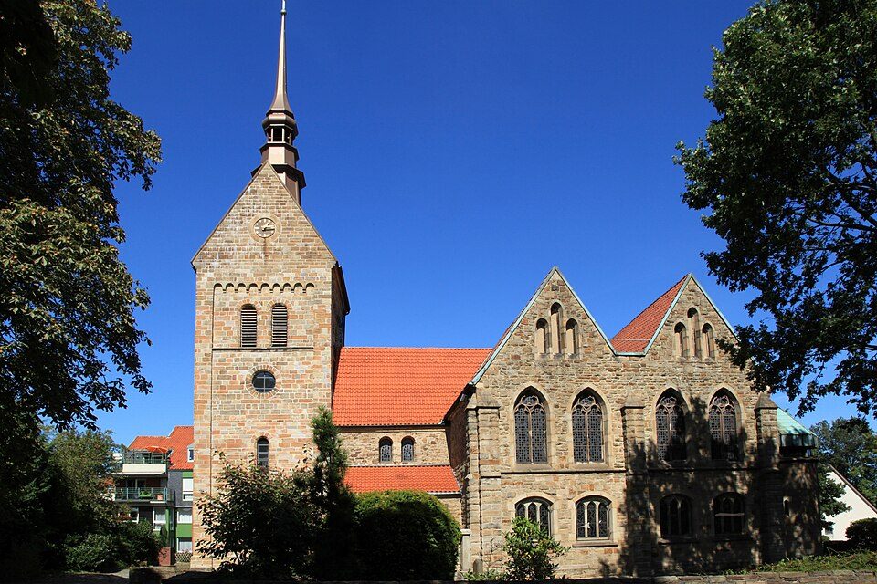 Die Kirche St. Vinzentius mit Bruchsteinturm und rotem Ziegeldach im alten Ortskern von Bochum-Harpen