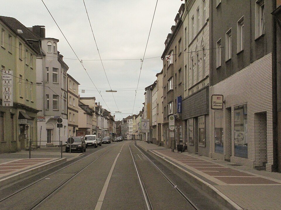 Hochstraße in Wattenscheid-Mitte mit Straßenbahnschienen und mehrgeschossigen Wohn- und Geschäftshäusern auf beiden Seiten