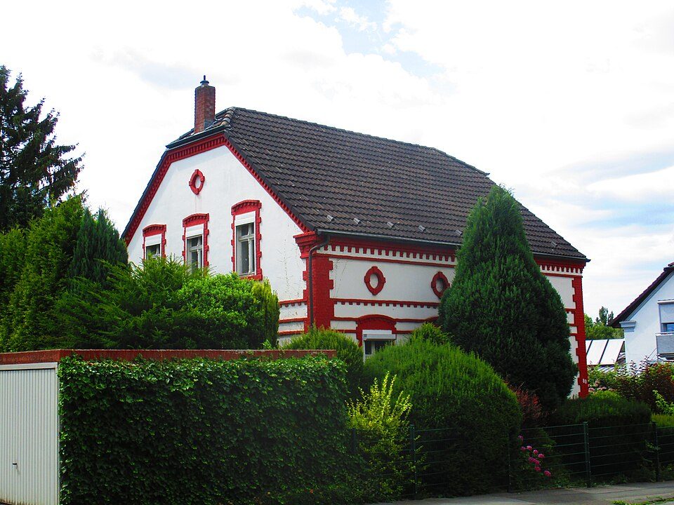 Weiß-rotes Wohnhaus mit Krüppelwalmdach und Garten hinter einer Hecke an der Karl-Friedrich-Straße in Bochum-Weitmar-Mark