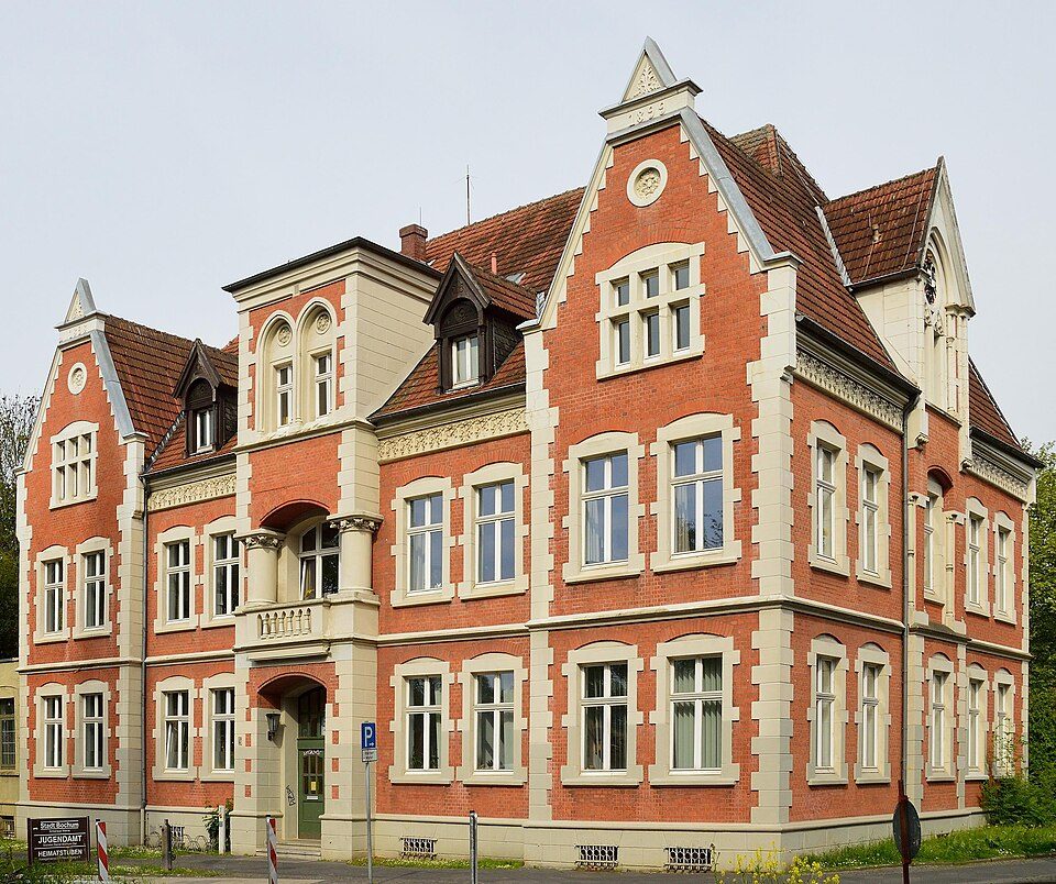 Historisches Amtshaus in Bochum-Werne, ein dreigeschossiger Backsteinbau mit hellen Fensterrahmen, Ziergiebeln und rotem Dach